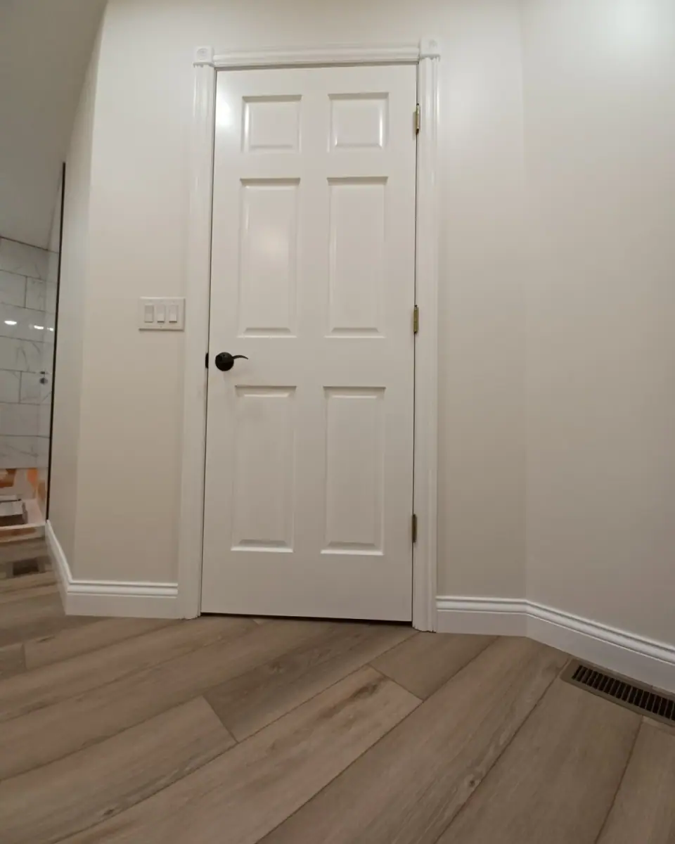 White six-panel interior door with trim and baseboard, finished by Dream Big Contracting