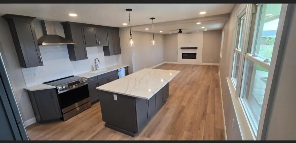 Finished kitchen with a large island and wood floors, a Dream Big Contracting remodel